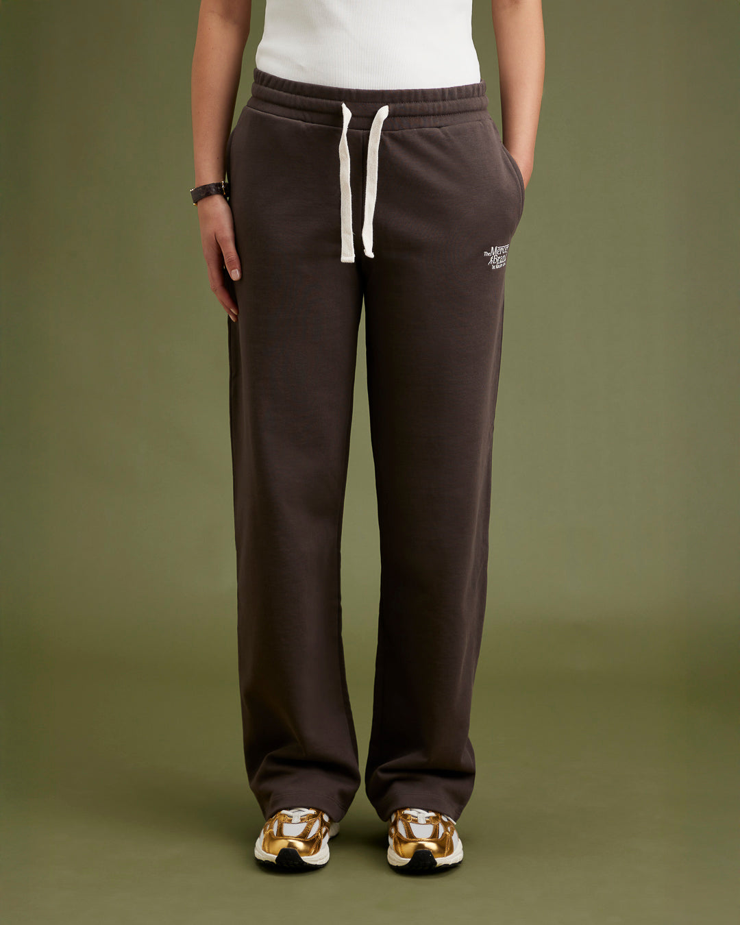 the mercer brand sneaker the re-run pine gold with off white details for women on foot close up 