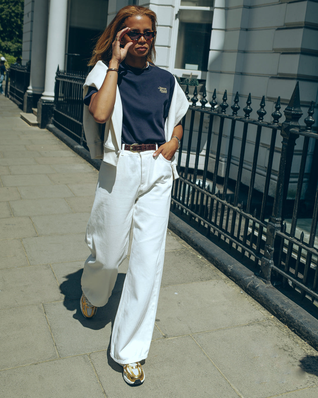 the mercer brand sneaker the re-run pine gold with off white details for women wearing navy shirt