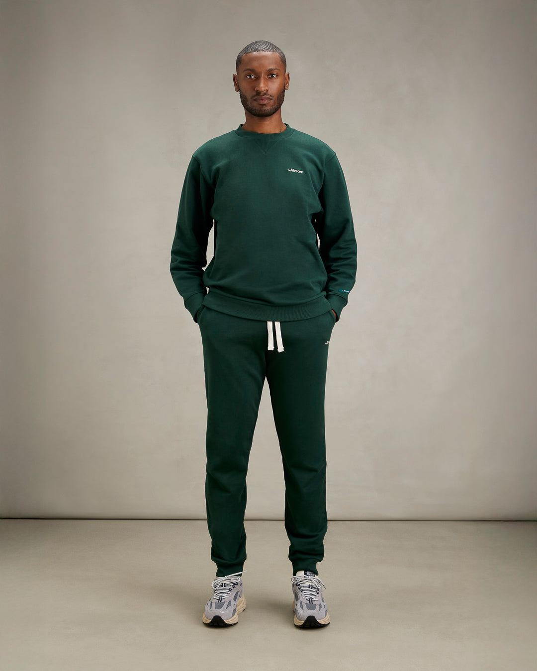 the mercer brand sneaker the re-run Vibram grey with speckled outsole full look for men studio shot with the mercer sweatpants and sweater green