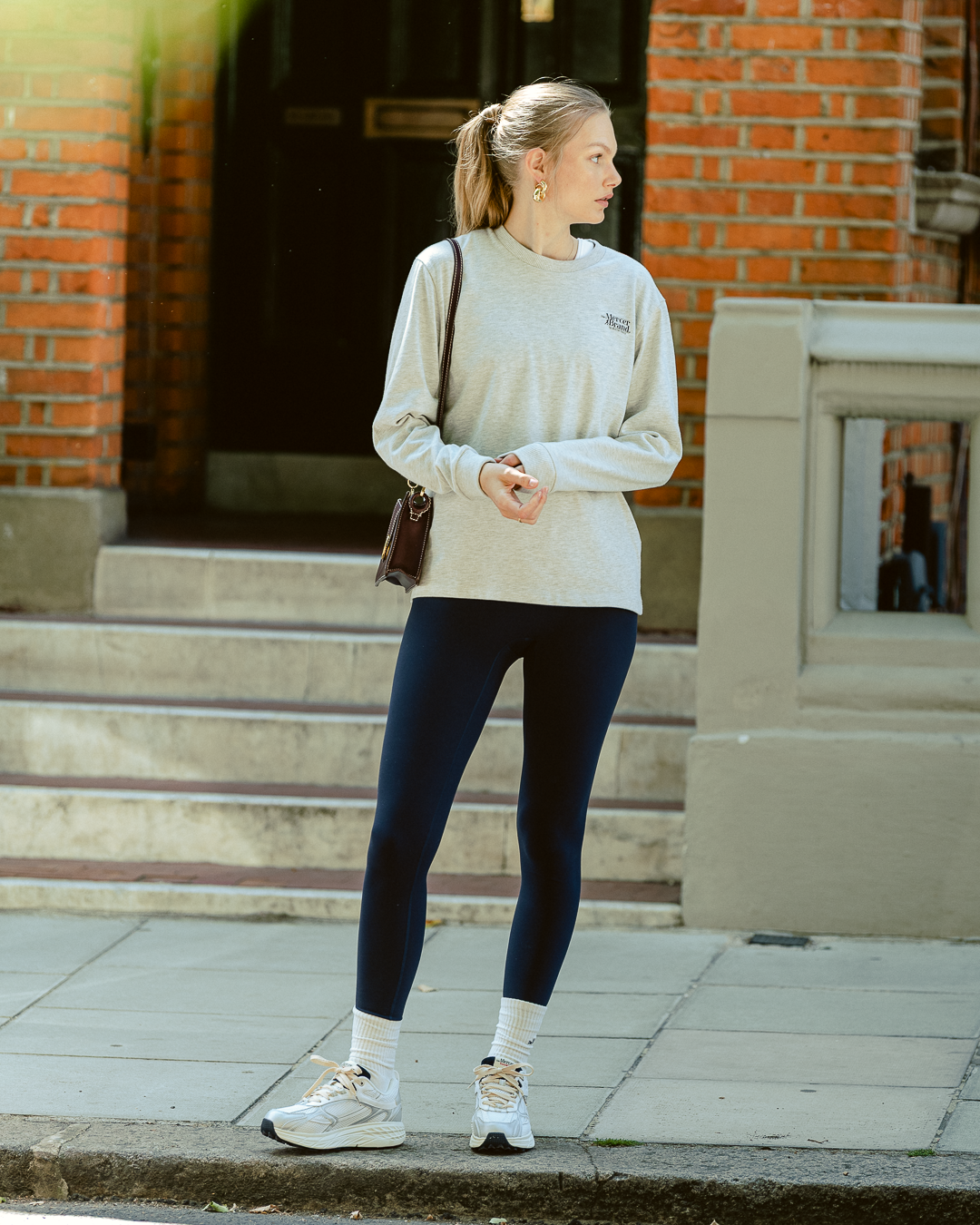 the mercer brand re-run max sneaker track and field white sneaker with cream laces and small navy details  full look women with long sleeve grey and legging navy