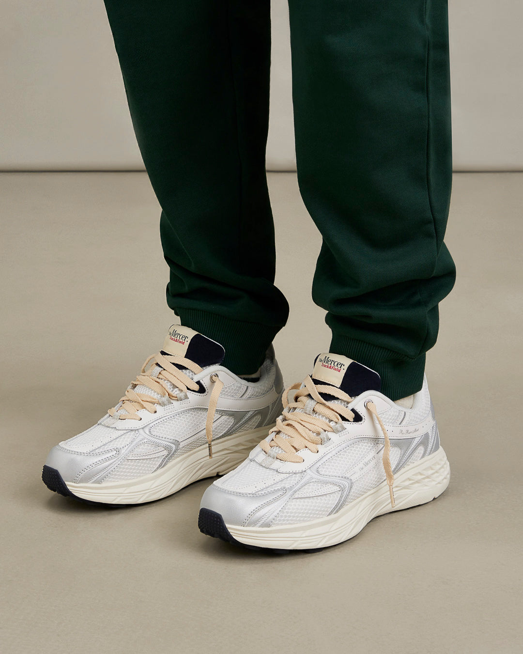 the mercer brand re-run max sneaker track and field white sneaker with cream laces and small navy details styled for men on-foot
