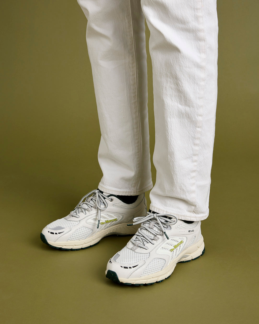 A man is wearing a jeans, paired with The Re-Run Evo in white.