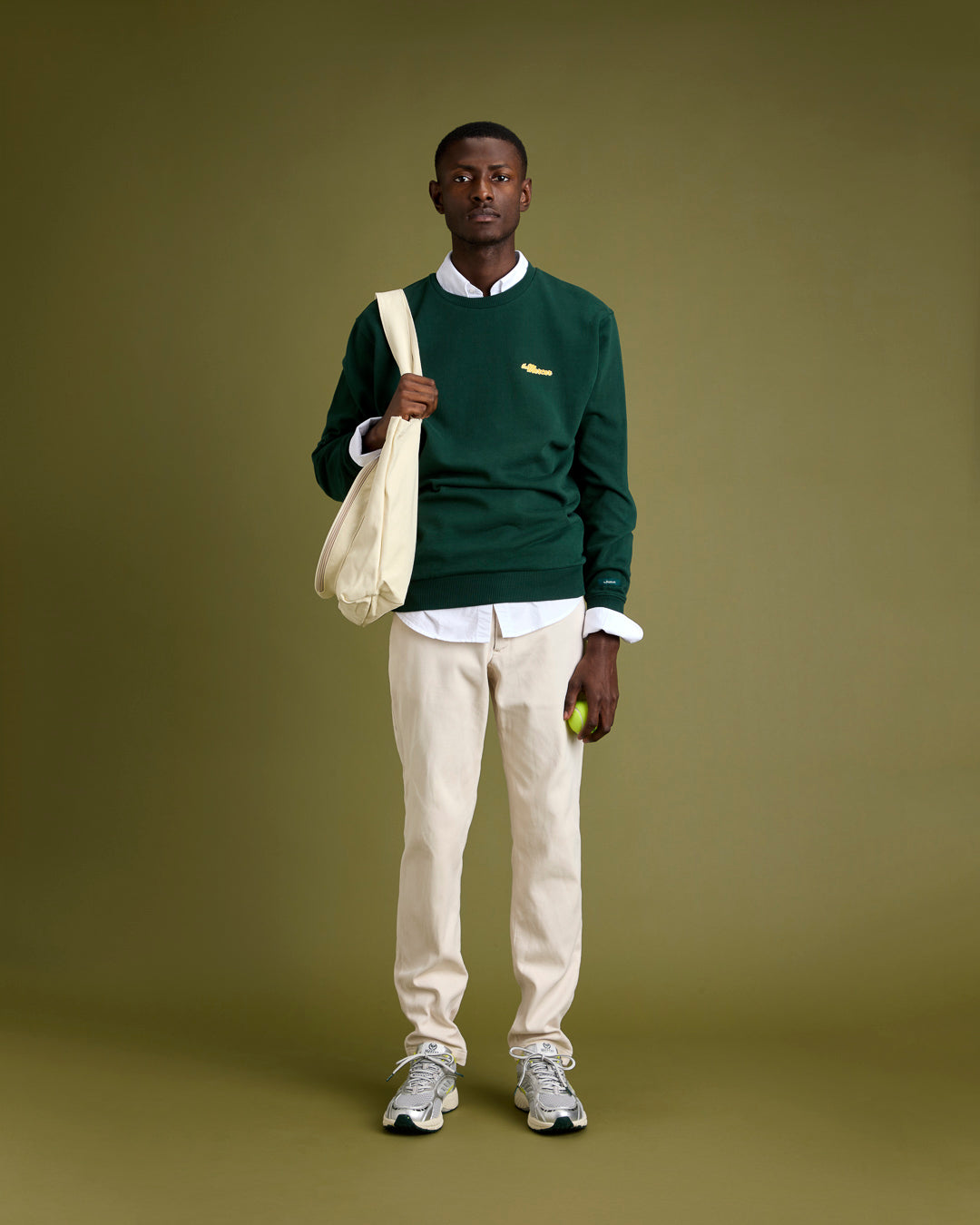 full length shot of male model wearing the re-run evo silver sneakers and green mercer logo sweat