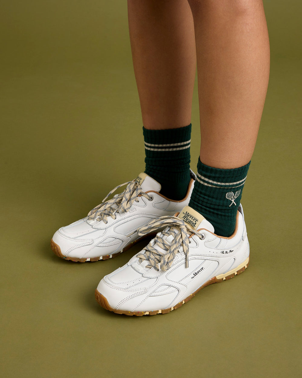 Woman wearing the Mercer Tennis Socks in green with The Re-Run Drive in white
