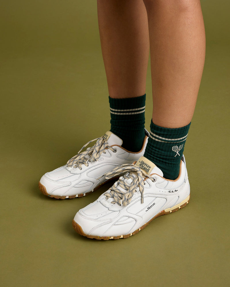Woman wearing the Mercer Tennis Socks in green with The Re-Run Drive in white