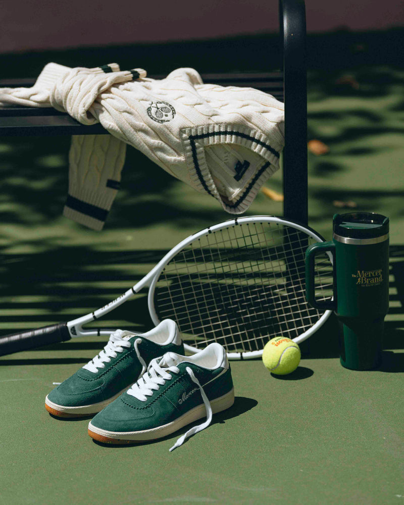 Re-Tennis in green is displayed on a tennis court, next to The Mercer Tumbler and a tennis sweater.