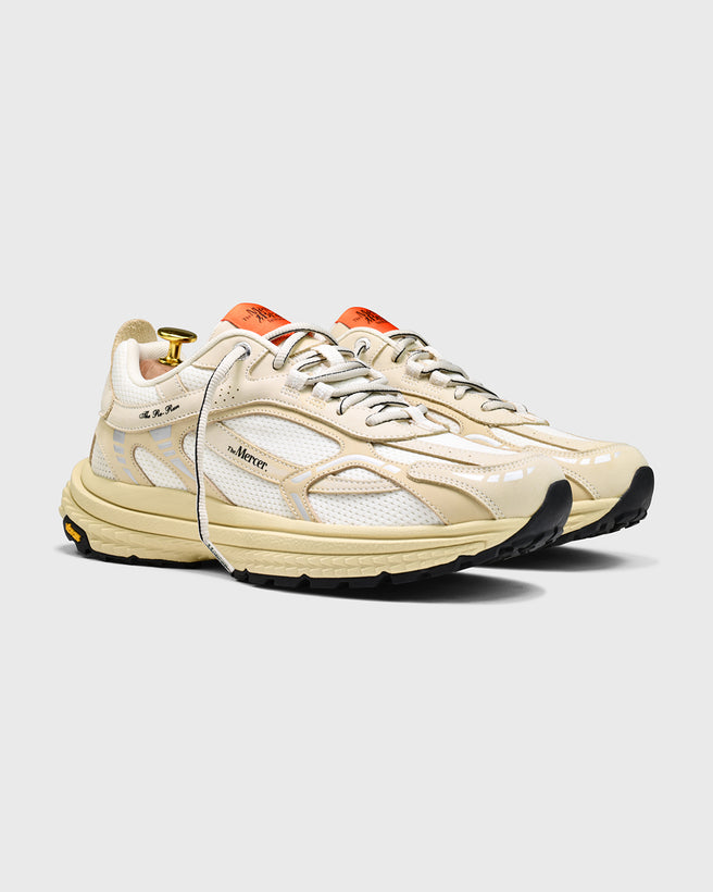 Product shot of the Re-Run Vibram in Off White from the side orange detail and thick sole sneaker by the mercer brand