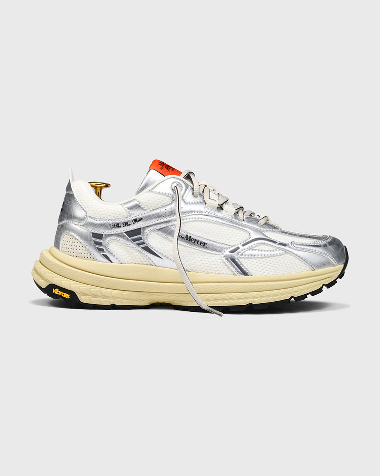 product shot of side profile of the The Re-Run Vibram in Silver with orange detail on the tongue of the sneaker by the mercer brand