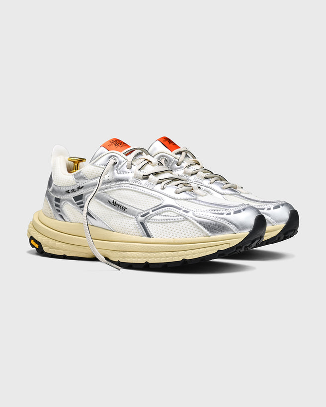product shot of side profile of the The Re-Run Vibram in Silver with orange detail on the tongue of the sneaker by the mercer brand