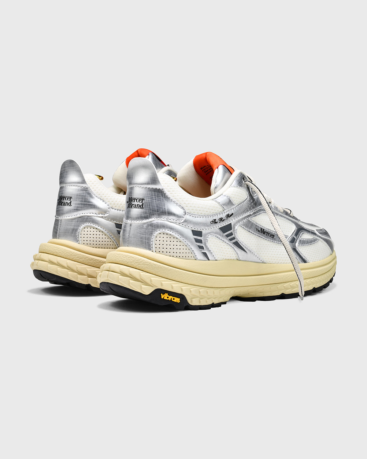Product shot of the The Re-Run Vibram in Silver with orange detail on the tongue of the sneaker by the mercer brand