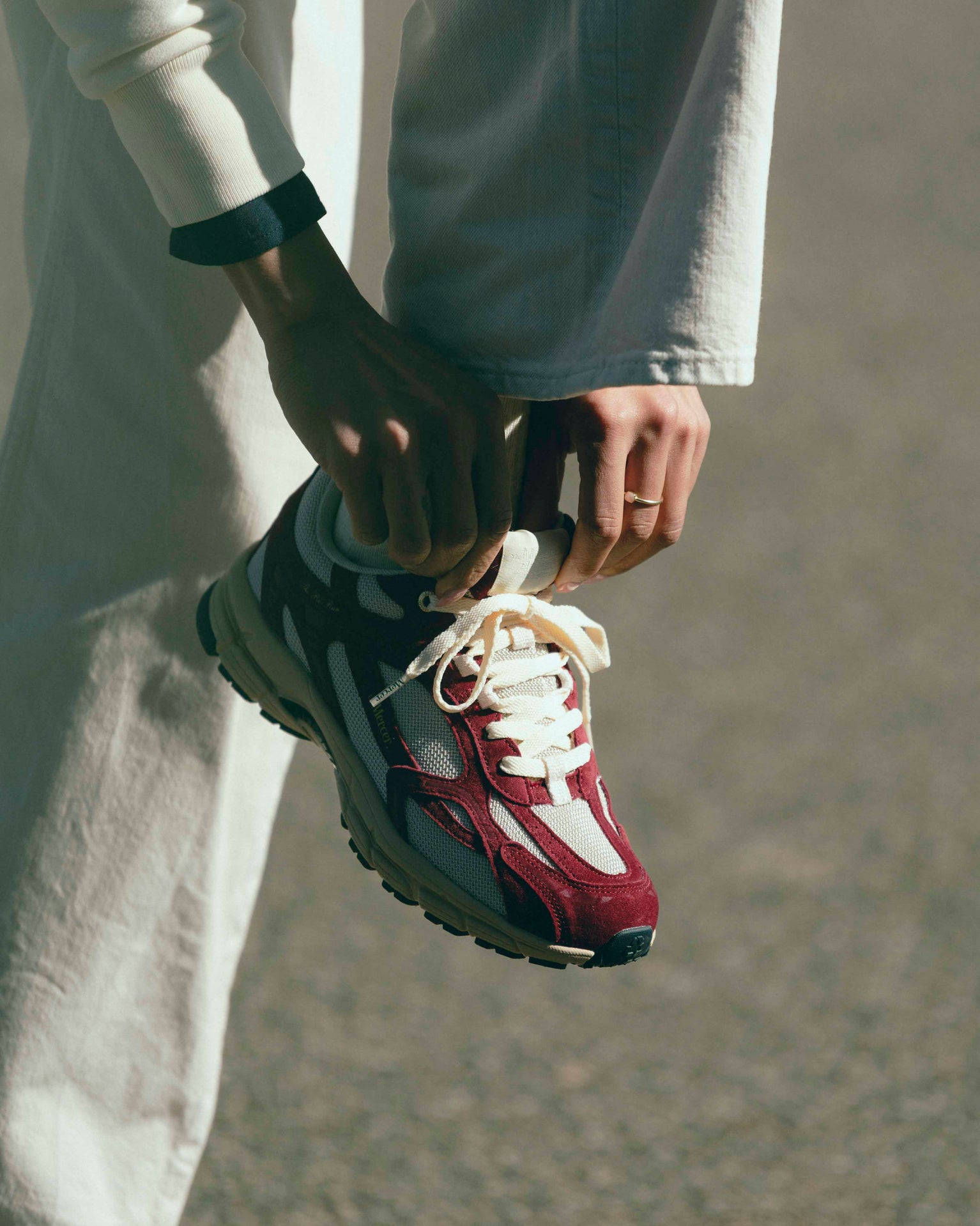 A Woman is tying her The Re-Run desert 2.0 in bordeaux.