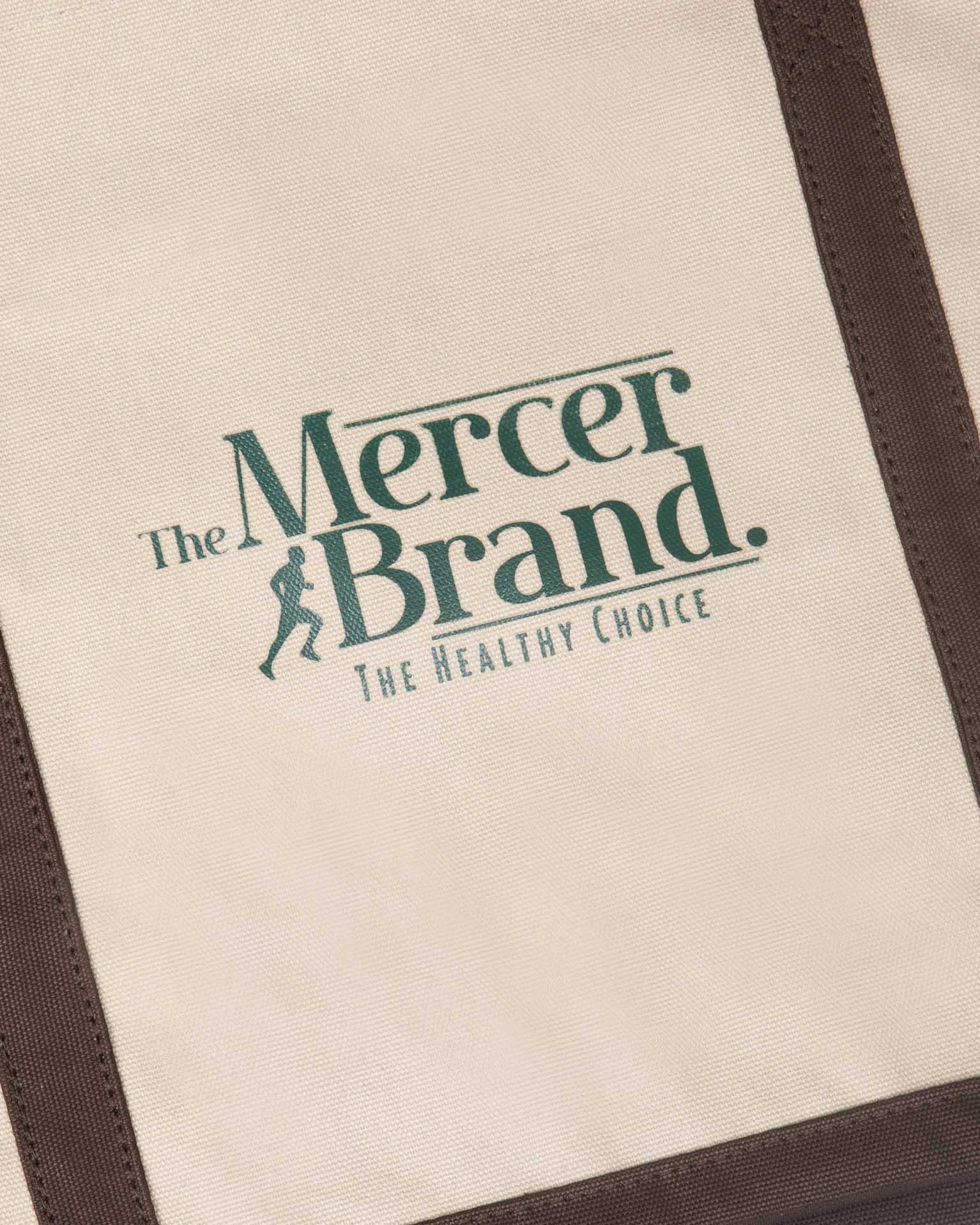 the mercer brand canvas bag brown with logo and dog on other side cream bag with brown details