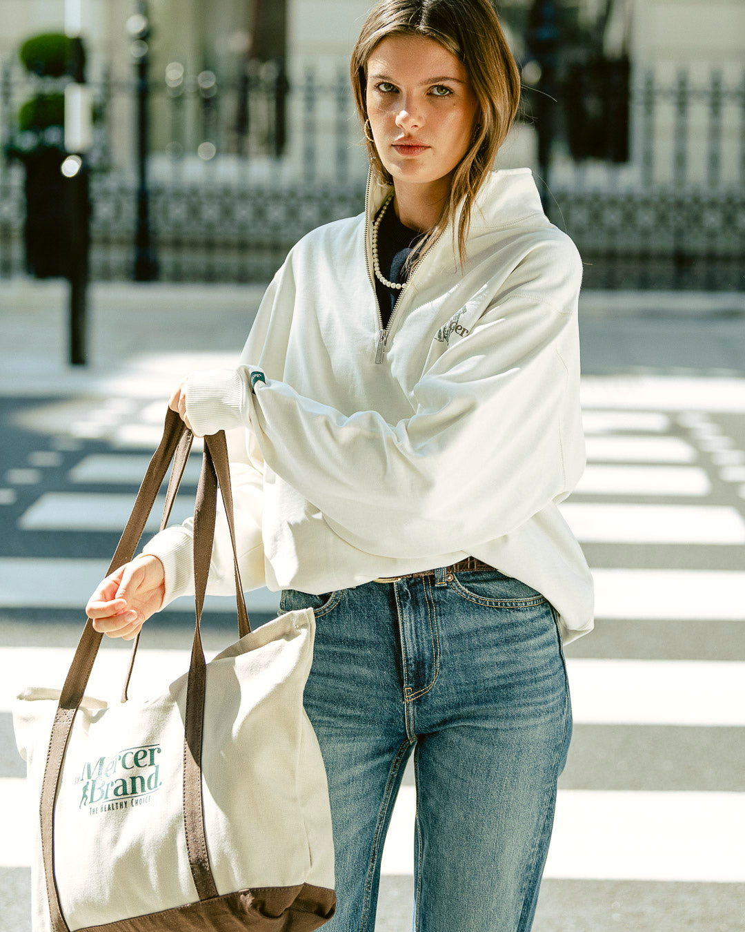 the mercer brand canvas bag brown with logo and dog on other side cream bag with brown details