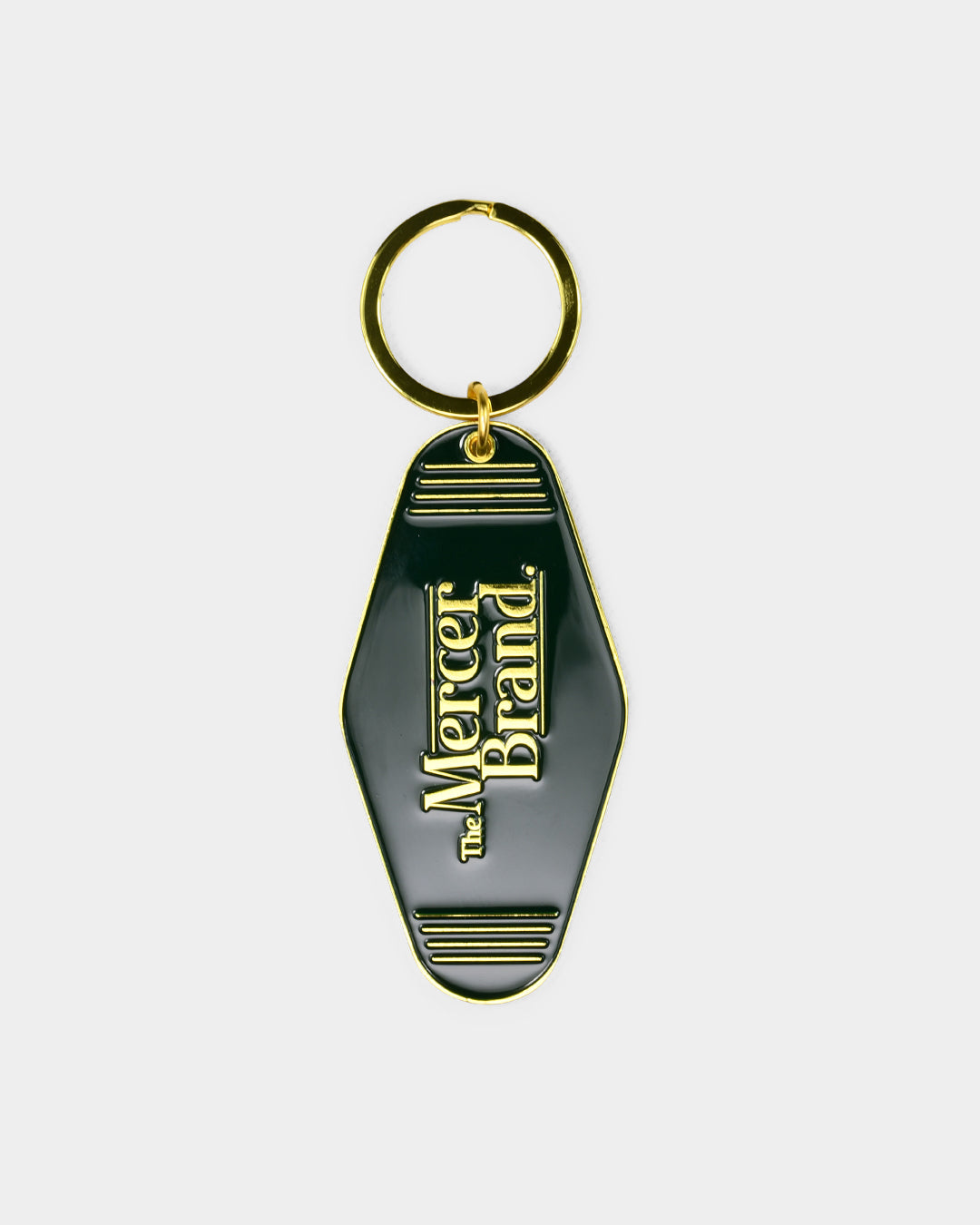 the mercer brand keychain green with gold details with logo and the mercer dog
