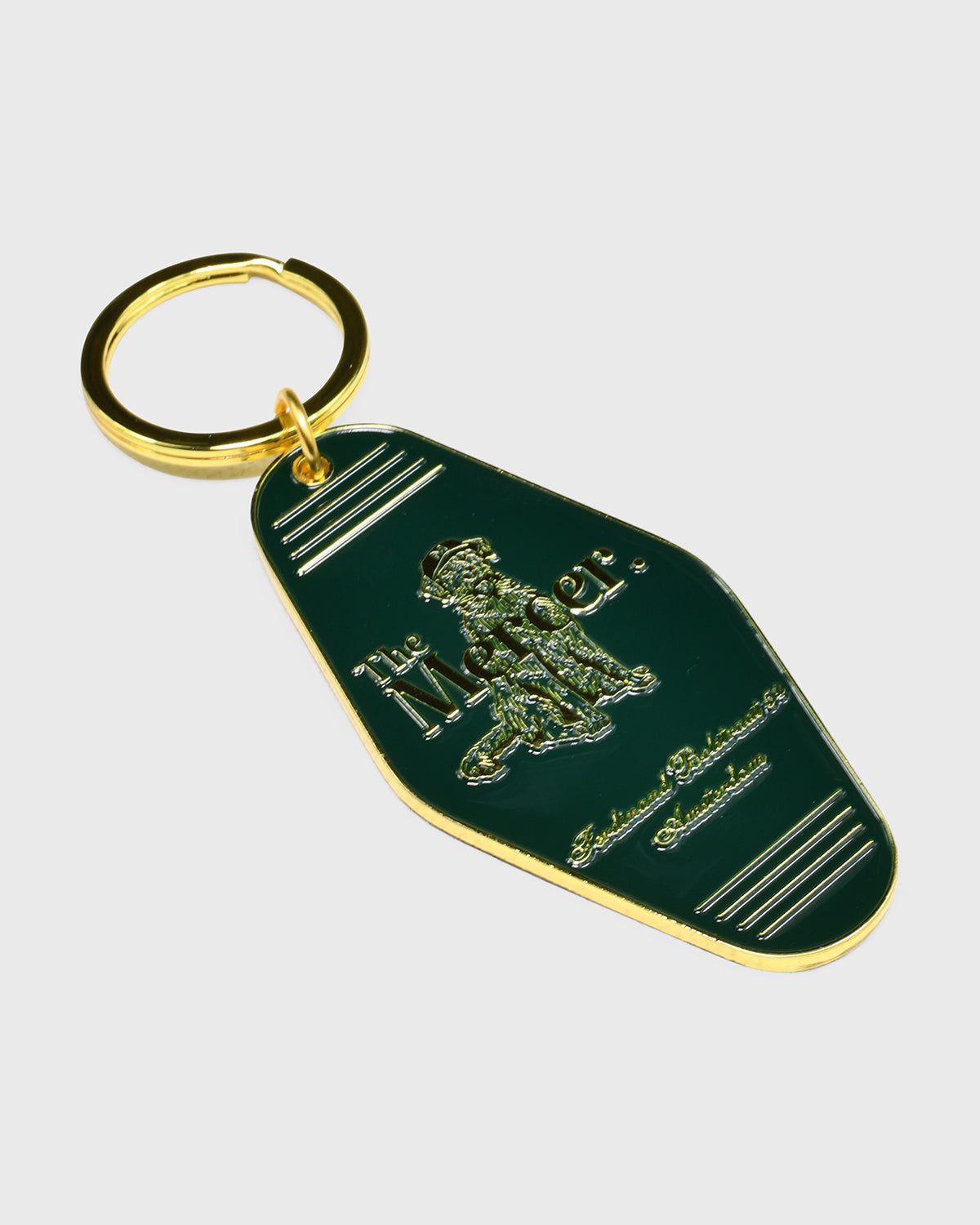 the mercer brand keychain green with gold details with logo and the mercer dog