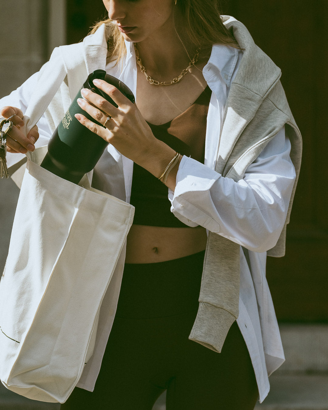 The Mercer Brand green tumbler with logo on light grey background