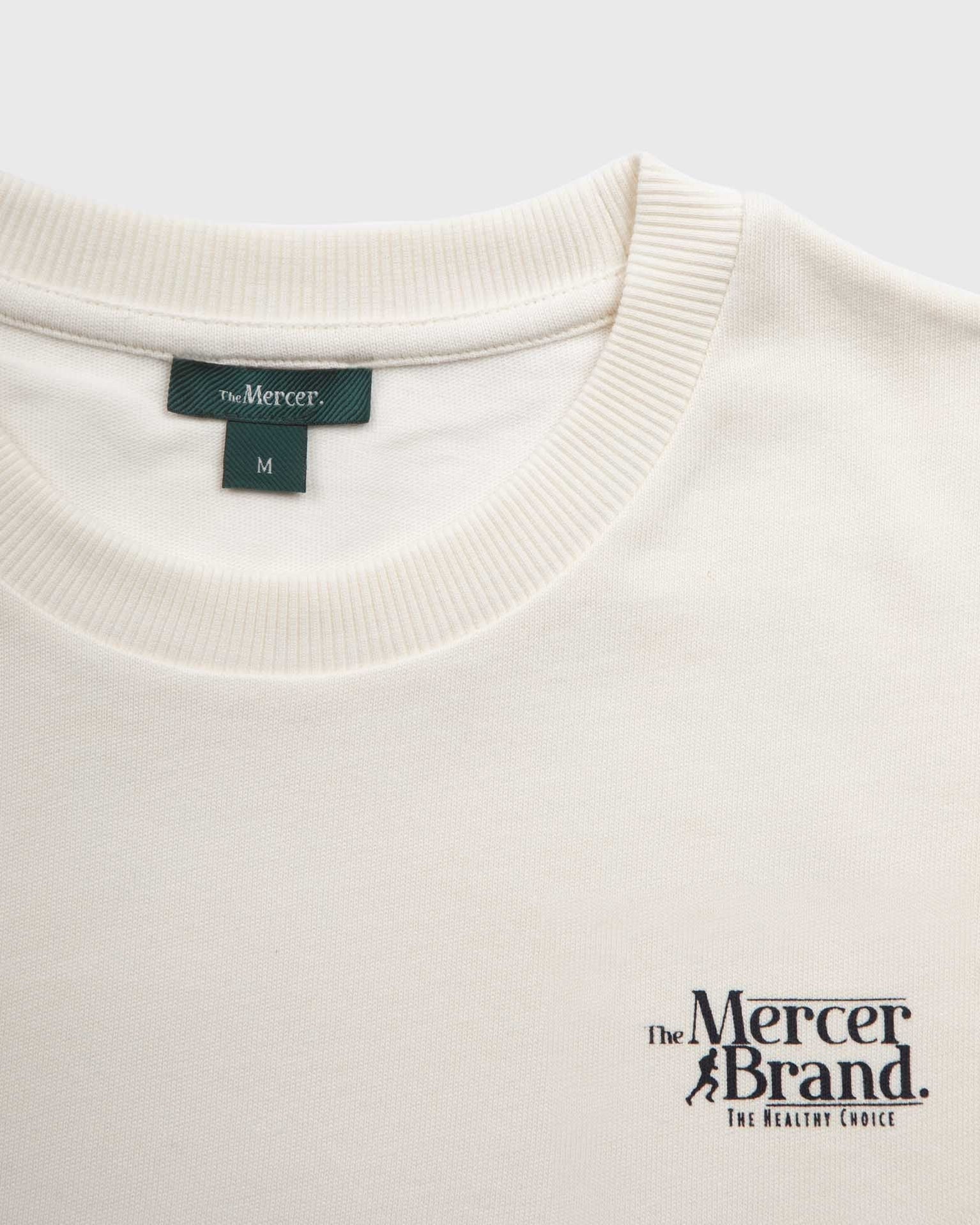 The mercer brand heavy tee off white product photo front with text 