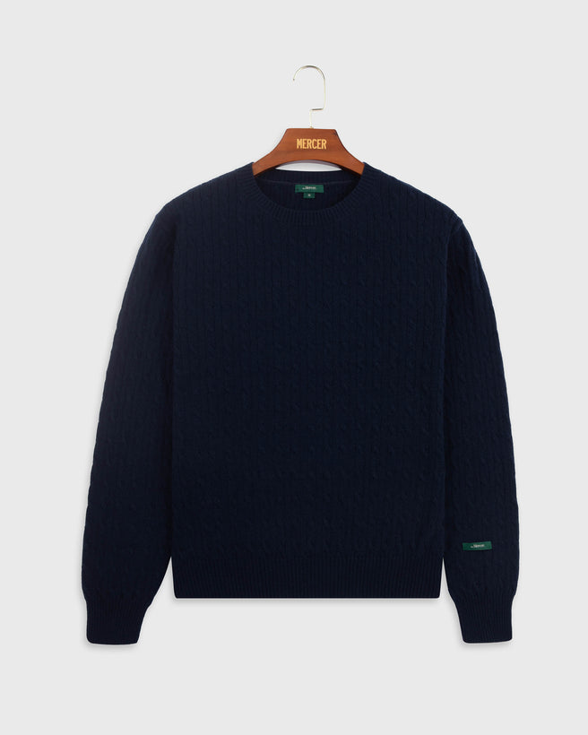 the mercer brand cable knit sweater cashmere navy with green logo on sleeve product photo front 
