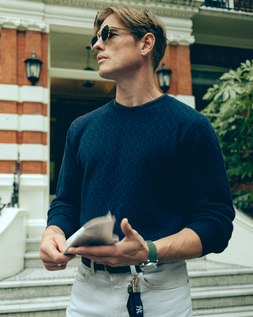 the mercer brand cable knit sweater cashmere navy with green logo on sleeve product photo front 