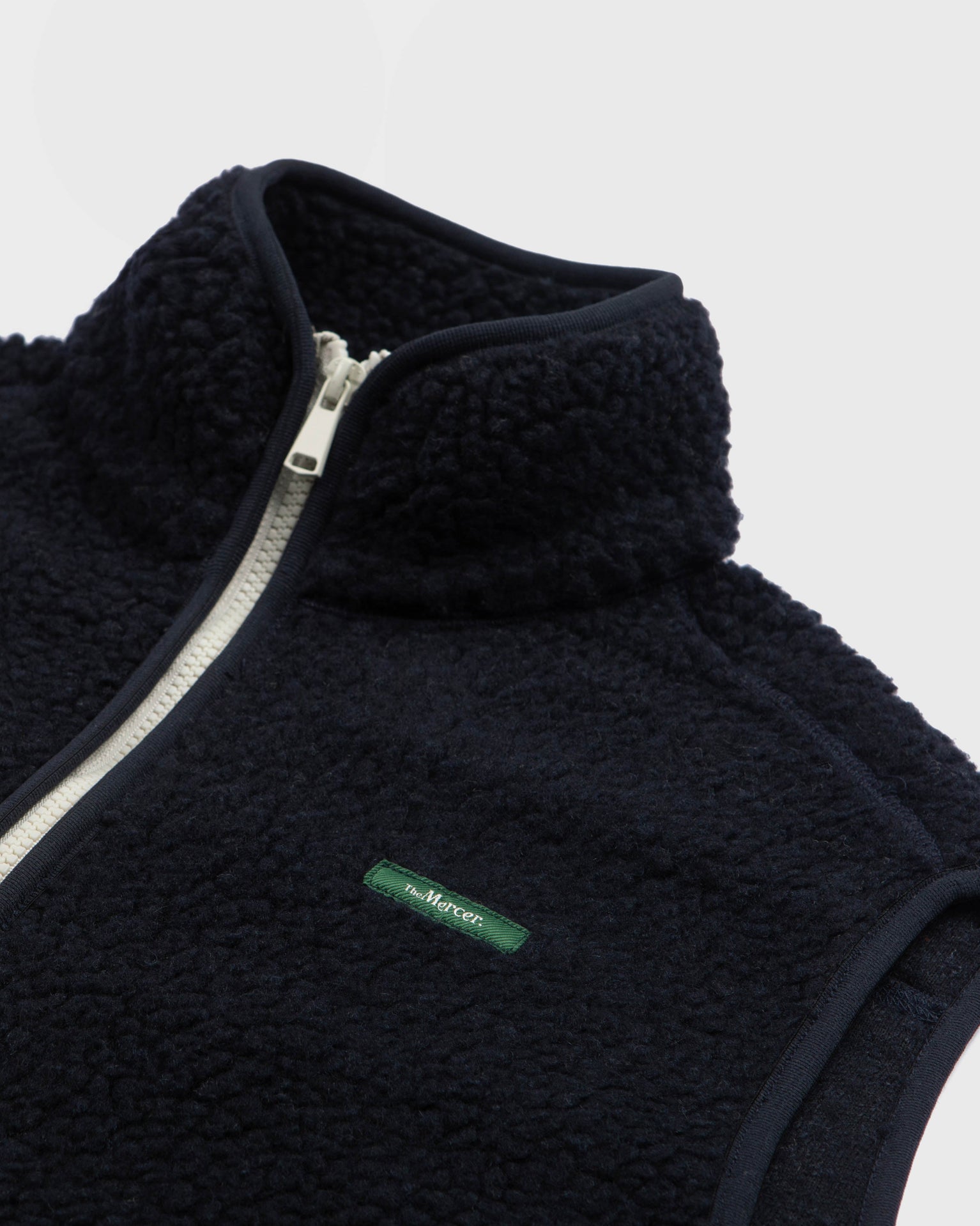 the mercer brand wool bodywarmer navy with green logo