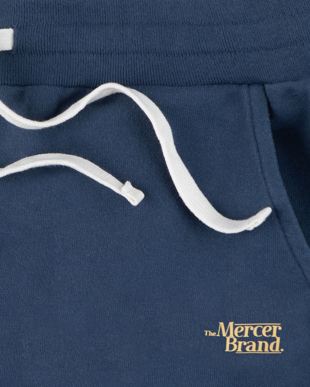 The Mercer Brand navy sweatpants with white drawstring on a light grey background